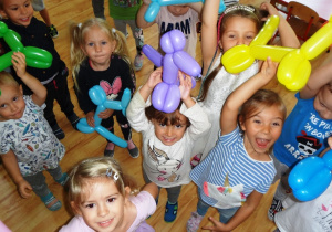 Dzieci trzymają baloniki w kształcie pieska